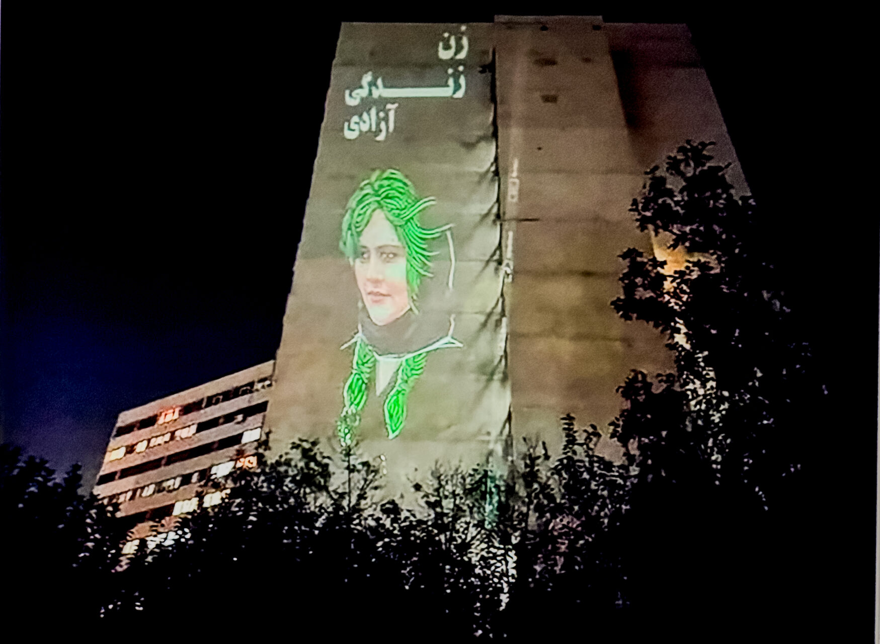 The face of Mahsa (Jina) Amini is projected on the buildings in the Ekbatan neighbourhood of Tehran, accompanied by the slogan "Woman, Life, Freedom." October 25, 2022, anonymous photographer