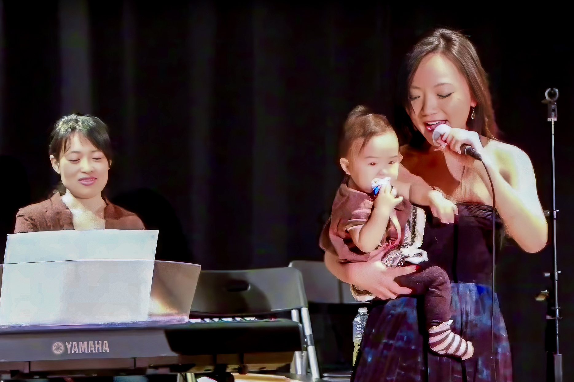 Asuca Hayashi sings while holding an audience member's baby, accompanied by pianist Takako Hatanaka, at CRS, 11/17/2012