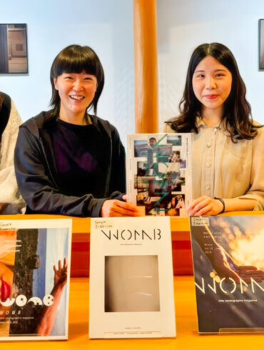 WOMB photographers Masami Ueda, Rino Kawasaki, Sana Kohmoto, and Kalina Leonard in front of the exhibit of WOMB magazines and photo books at their 10th anniversary exhibition at the Kyoto Museum of Photography