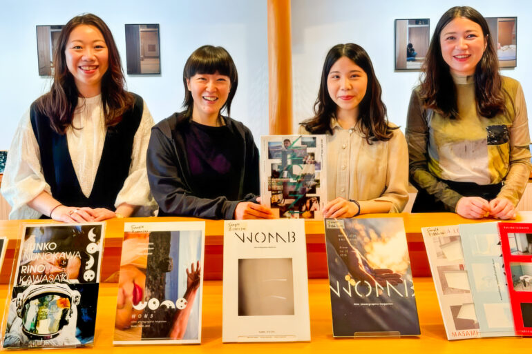 WOMB photographers Masami Ueda, Rino Kawasaki, Sana Kohmoto, and Kalina Leonard in front of the exhibit of WOMB magazines and photo books at their 10th anniversary exhibition at the Kyoto Museum of Photography